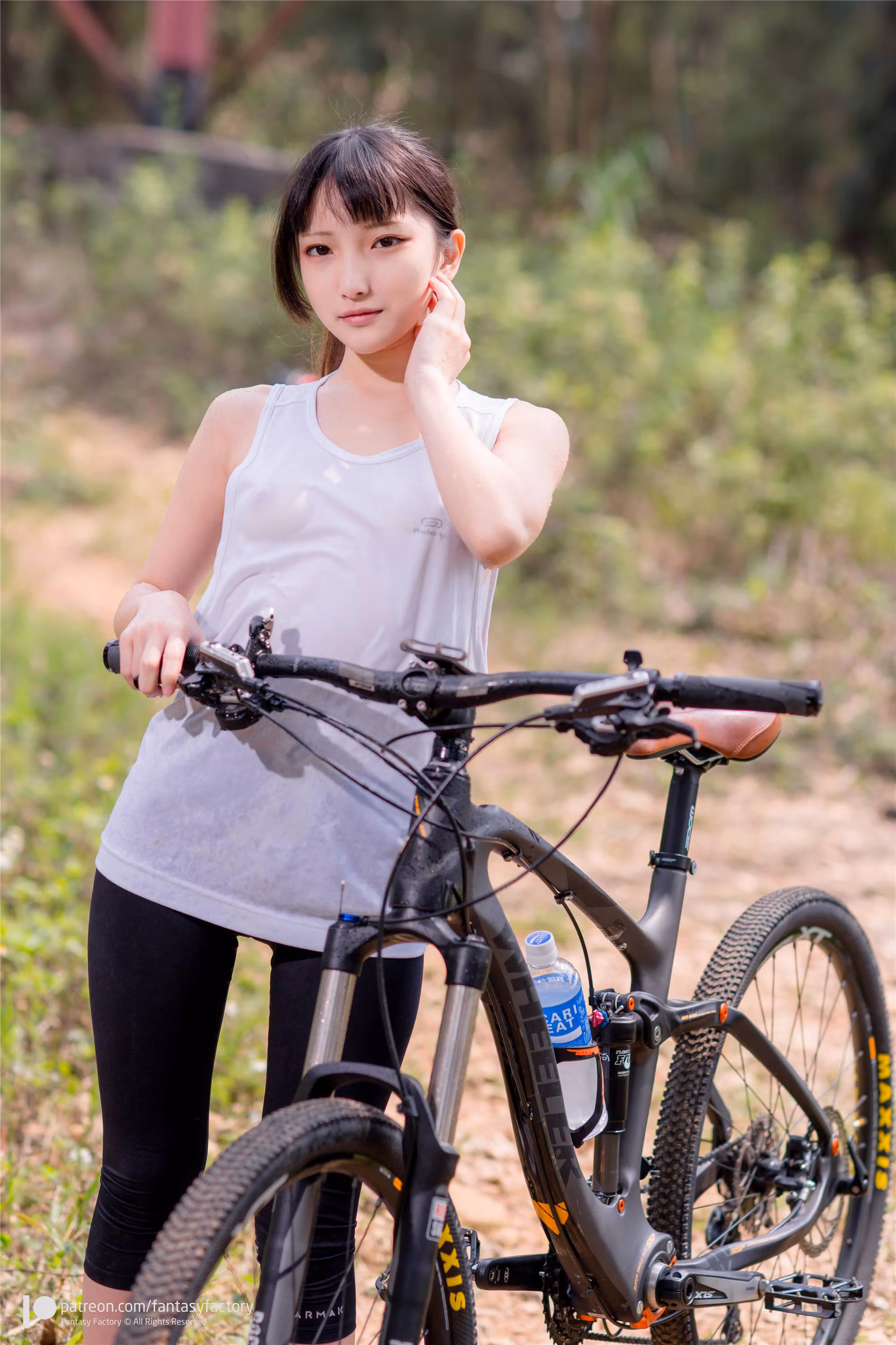 FantasyFactory清纯少女身穿白色运动背心与黑色紧身裤手持头盔趴在山地单车旁姿势